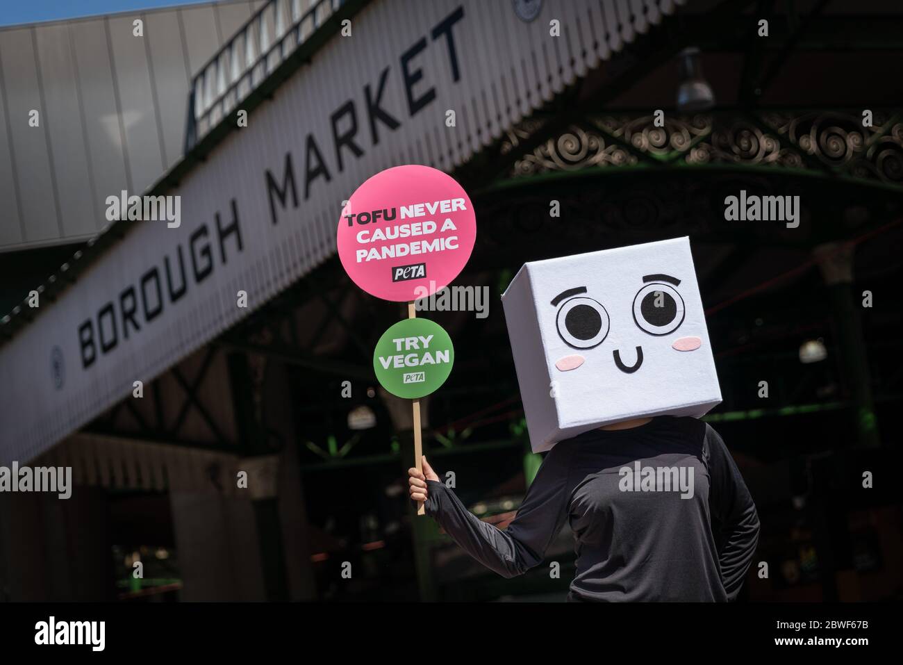 Londra, Regno Unito. 1 Giugno 2020. GLI attivisti per i diritti degli animali DI PETA hanno scritto 'tofu mai causato una pandemia', dice 'Block of tofu' al Borough Market di Southwark. Mentre le imprese e i mercati non essenziali iniziano a riaprirsi in tutta Londra, un attivista PETA vestito da blocco di tofu si trova fuori Borough Market con il segno "tofu Never caused a Pandemic!" esortare gli acquirenti a risparmiare animali, proteggere il pianeta e prevenire la diffusione di patogeni animali mangiando vegani. Credit: Guy Corbishley/Alamy Live News Foto Stock