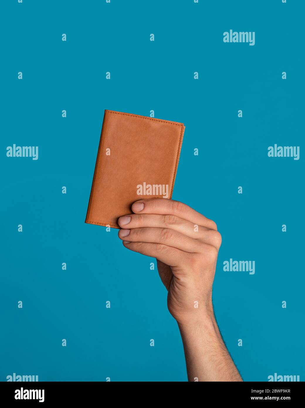 Ragazzo irriconoscibile che mostra passaporto su sfondo a colori, vicino di mano Foto Stock