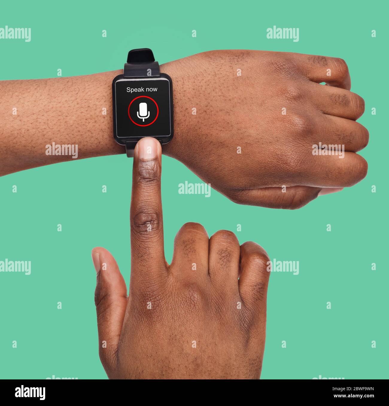 Mani maschili con Smartwatch Voice Assistant su sfondo Green Studio Foto Stock