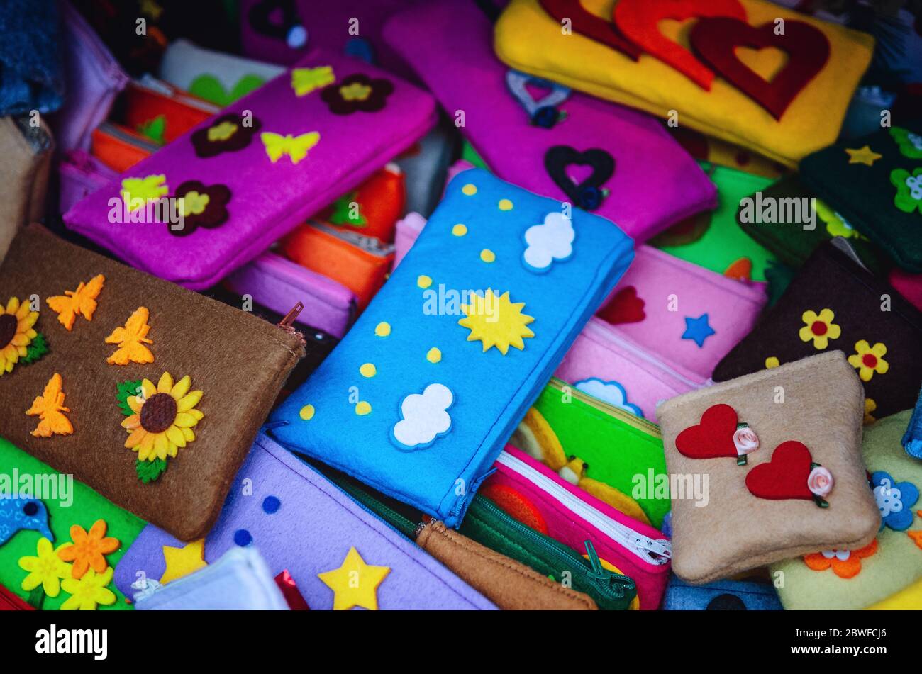 molti feltri portamatite fatti a mano per la scuola dei bambini, con fiori, nuvole e decorazioni a forma di cuore Foto Stock