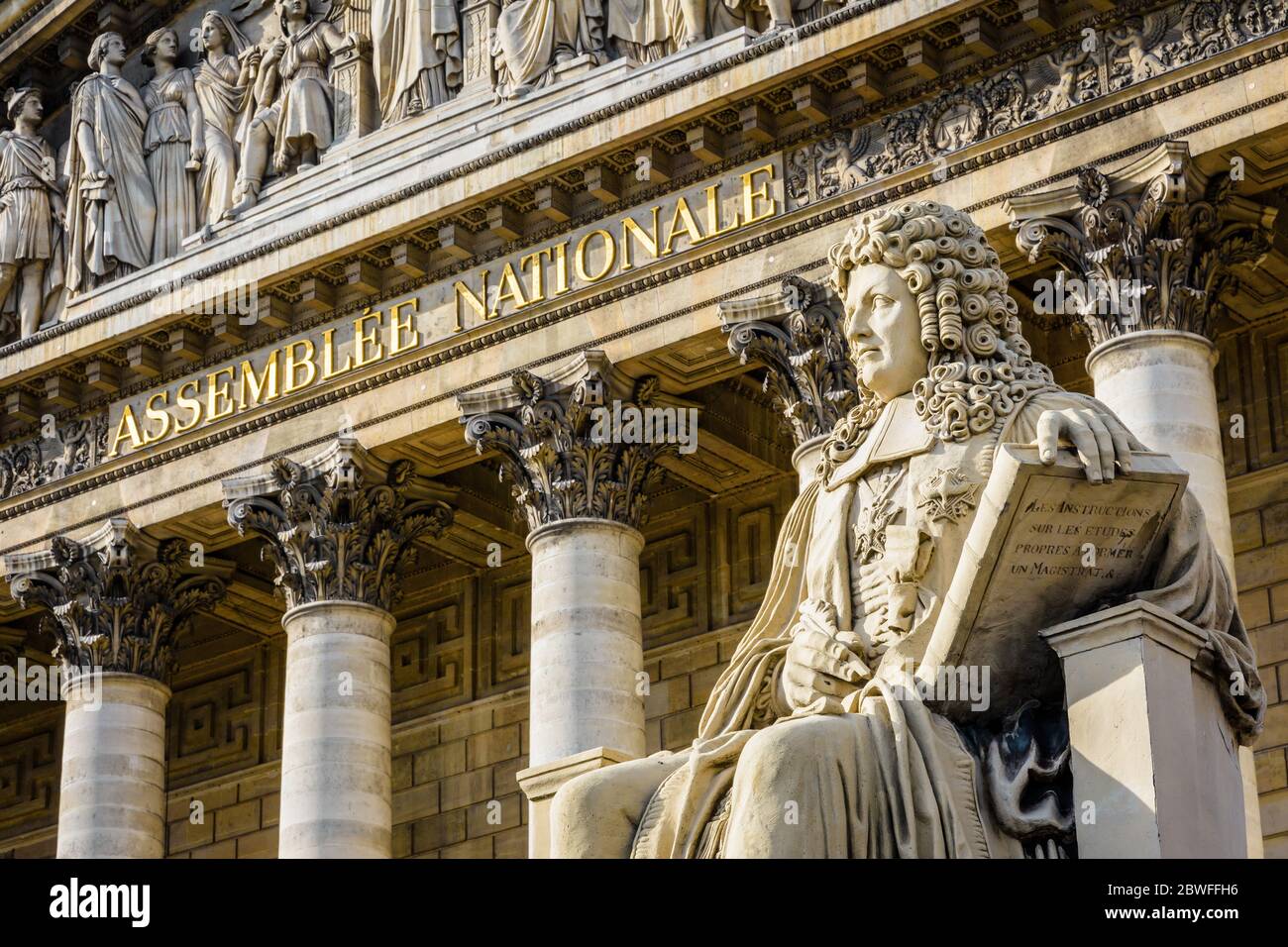 Primo piano della statua di Francois d'Aguesseau e l'iscrizione Assemblee Nationale in lettere d'oro sul fronte neoclassico del Palais Bourb Foto Stock