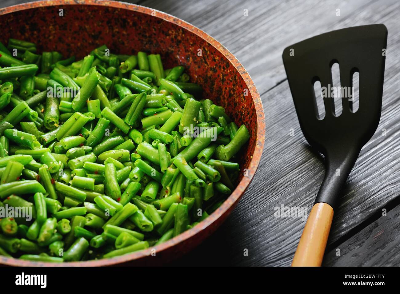 Cibo vegetariano. Fagioli fritti in una padella. Sfondo elegante per il design. Minimalismo. Cibo sano dalle verdure. Foto Stock