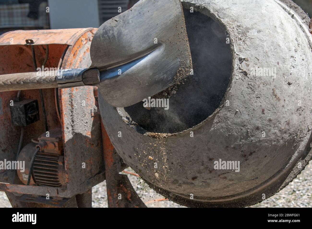 Mettere sabbia con una pala in cemento/Malta portatile Foto Stock