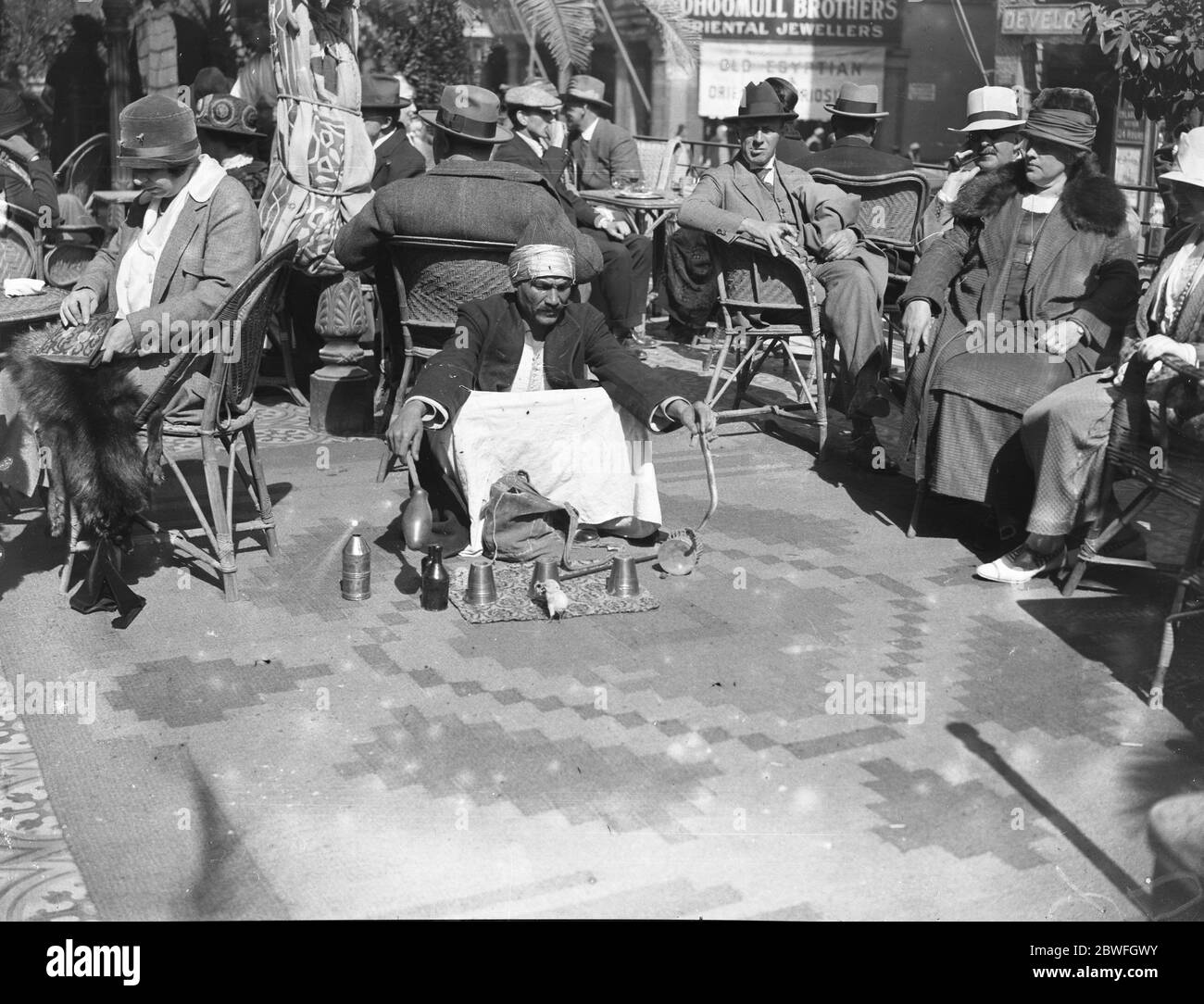 La Stagione del Cairo . Il conjurer nativo intrattiene gli ospiti sulla terrazza dello Shepheard Hotel . Febbraio 1925 Foto Stock