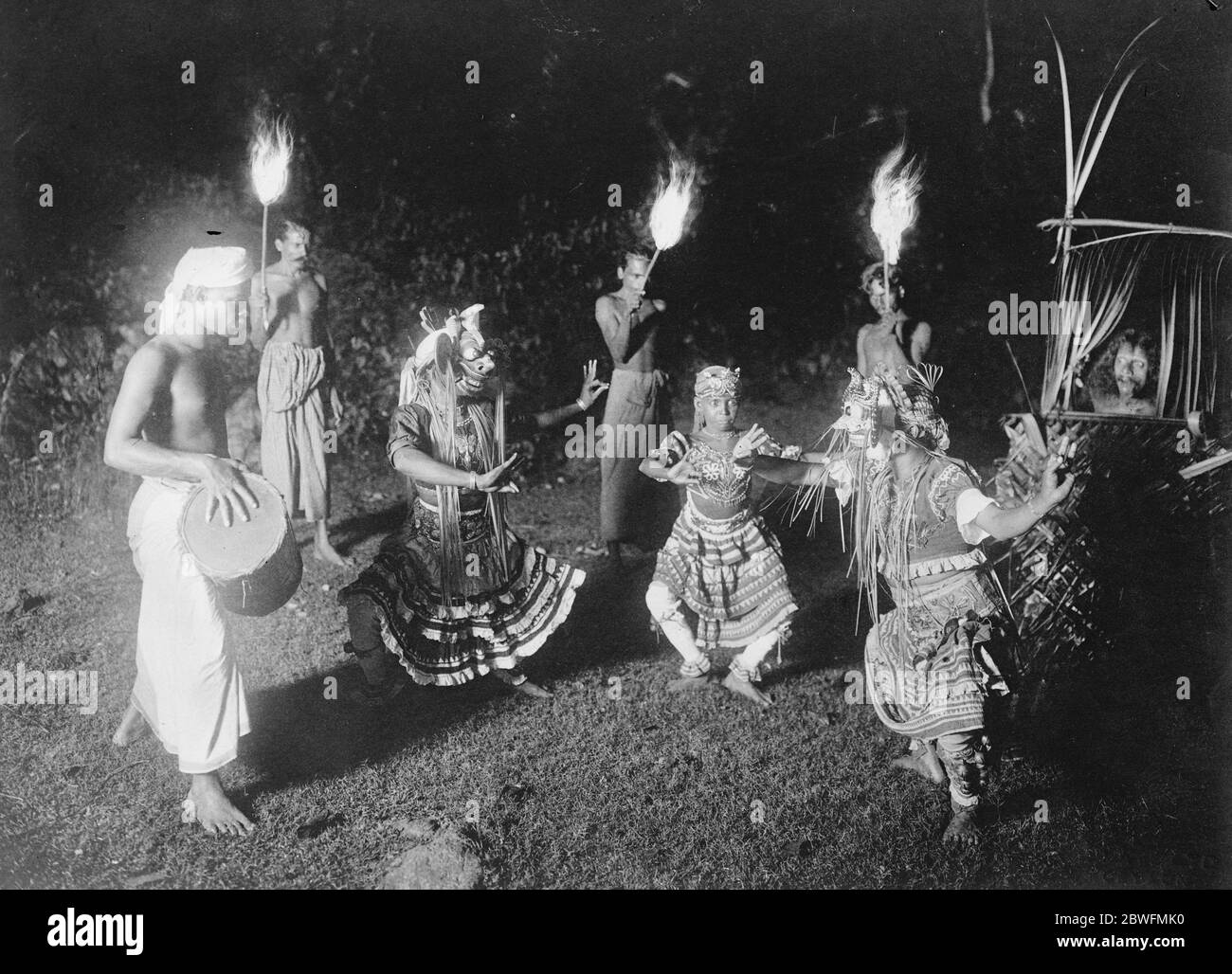 Dove sopravvivono riti medievali . Una foto di Ceylon , che mostra i ballerini del diavolo che esercitano uno spirito malvagio con la luce del torchiore . La persona afflitta è vista nel rifugio di bambù . 25 gennaio 1927 Foto Stock