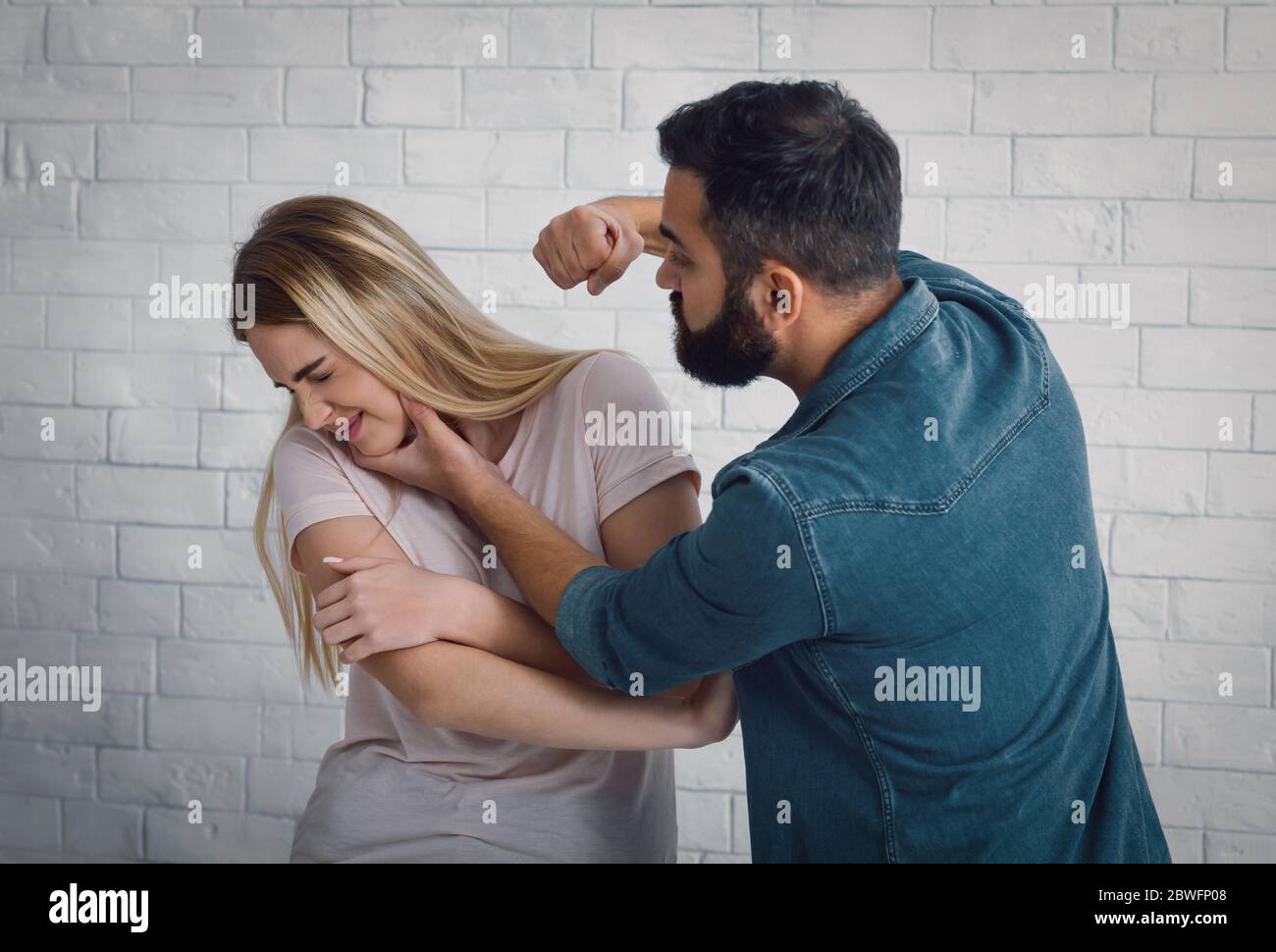 Aggressione a casa. Marito batte la moglie, la donna si gira Foto Stock