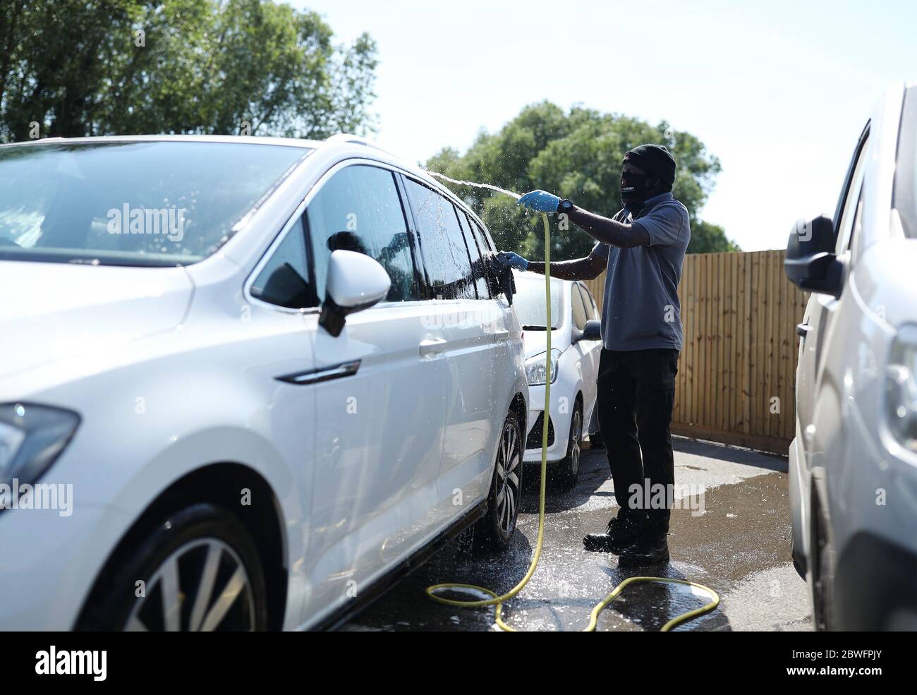 Personale addetto alla pulizia delle auto presso il concessionario Motorpoint Chingford nel nord di Londra, mentre gli showroom delle auto riaprono al pubblico a seguito dell'introduzione di misure per far uscire l'Inghilterra dalla chiusura. Foto Stock