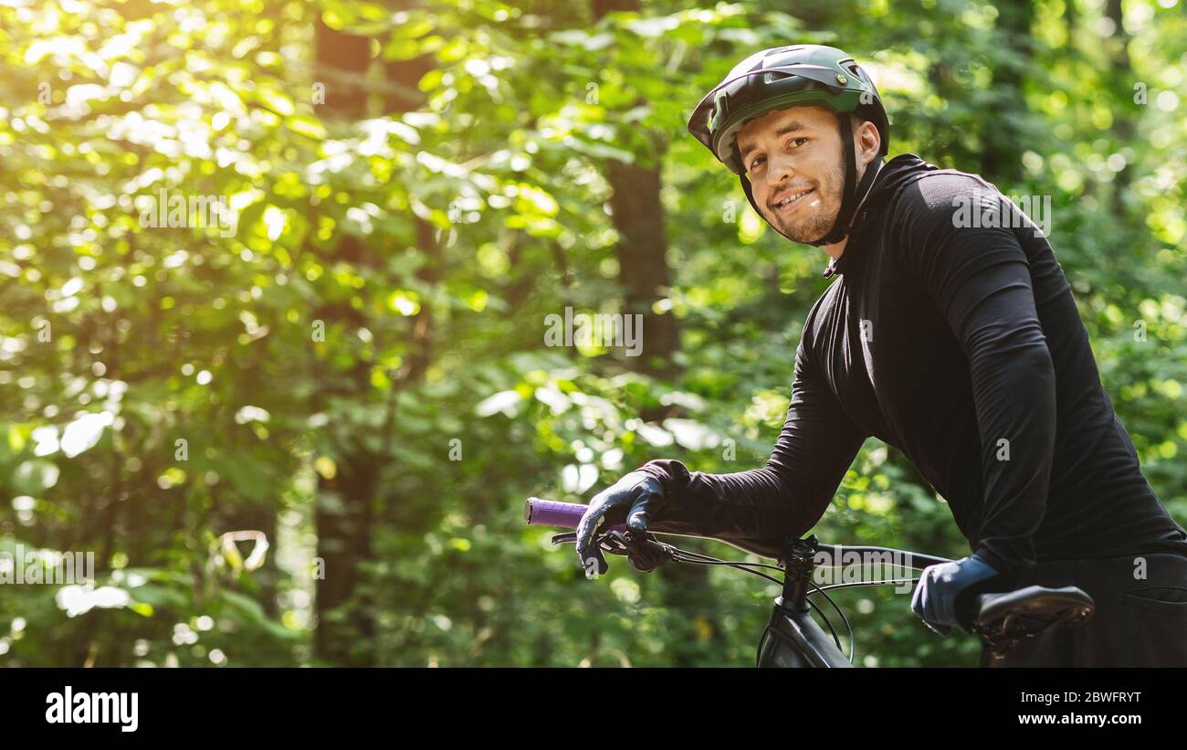 Ritratto di giovane biker che si è spezzato in foresta Foto Stock