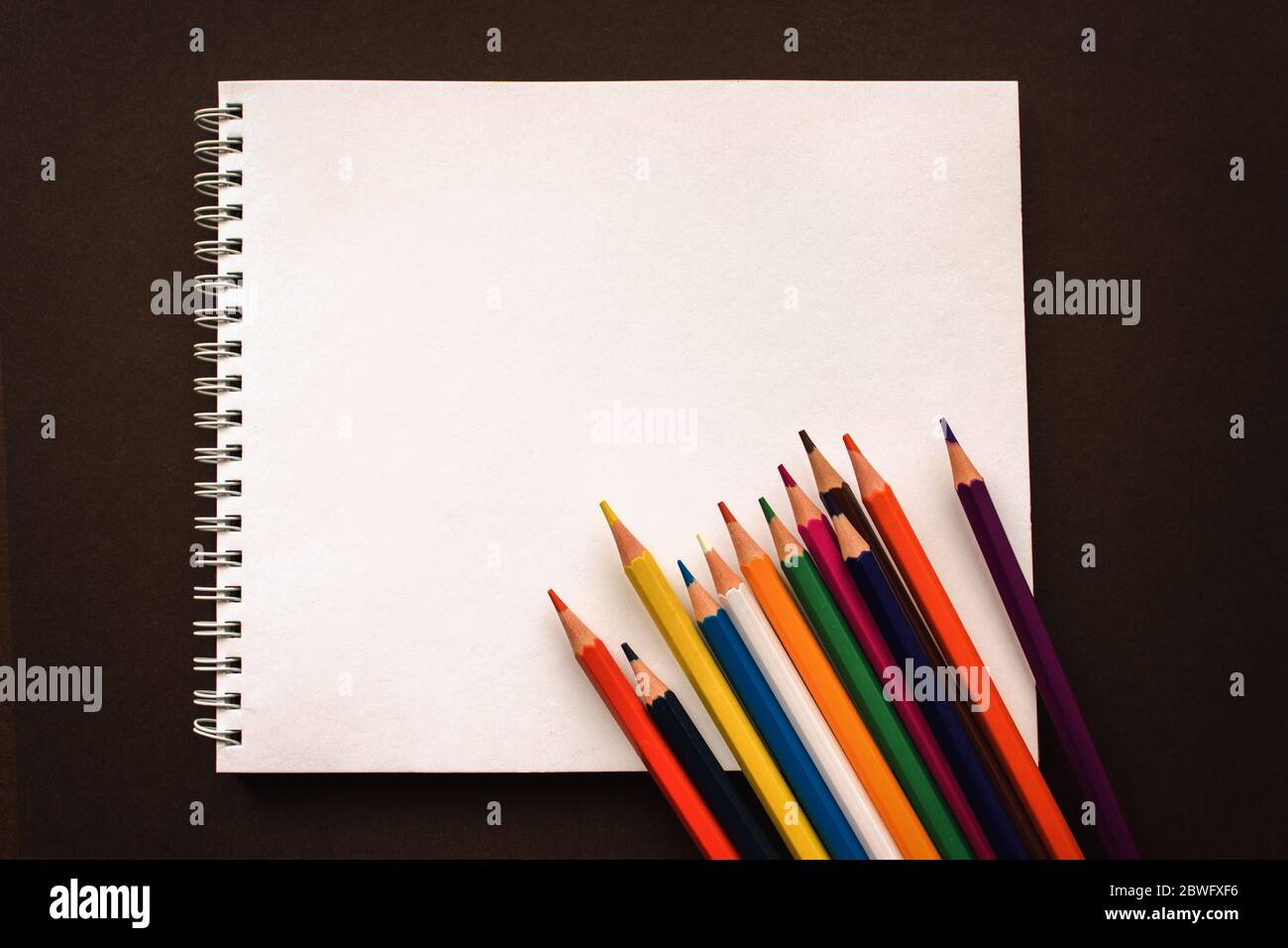 Art Sketchpad colorato Pencilson sfondo marrone, concetto di ritorno a scuola Foto Stock