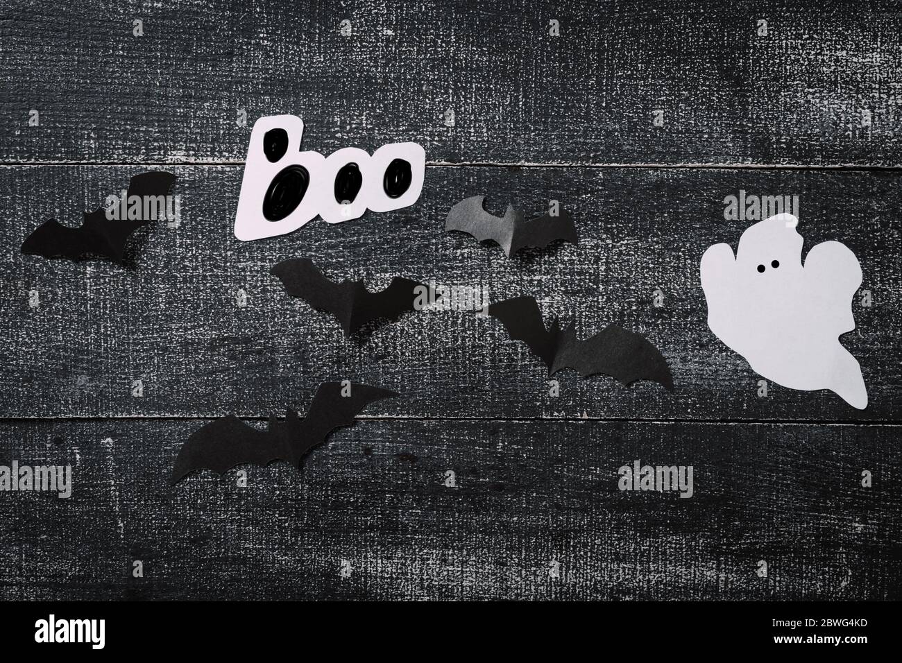 Costume fantasma bianco su sfondo nero scuro di legno. Concetto minimalista di Halloween. Carta tecnica fantasma Foto Stock