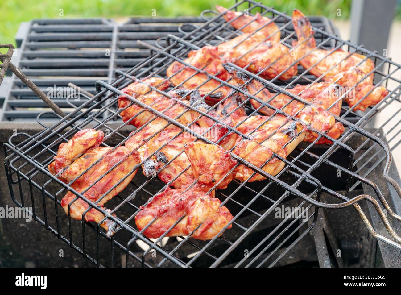 Ali di pollo alla griglia con fuoco da vicino Foto Stock