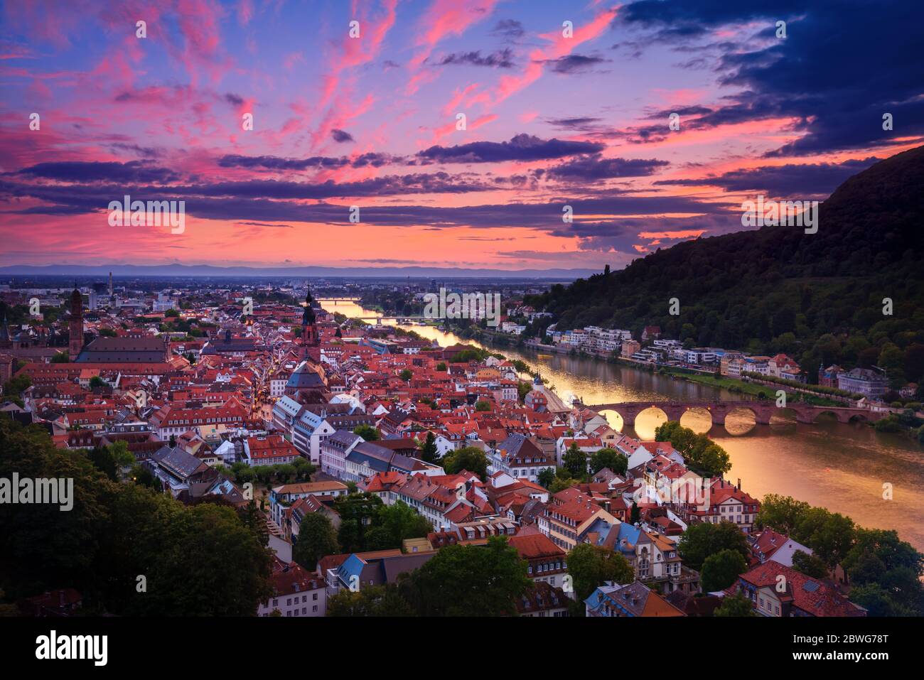Romantica vista aerea di Heidelberg con il fiume Neckar, in Germania, un suggestivo bagliore con vivaci colori rosso e viola dopo il tramonto Foto Stock