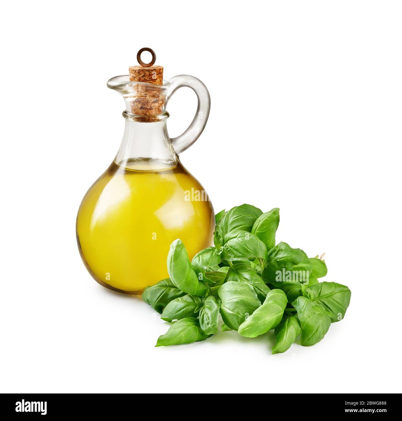 Vaso di vetro di olio d'oliva con foglie di basilico isolate su bianco. Foto Stock