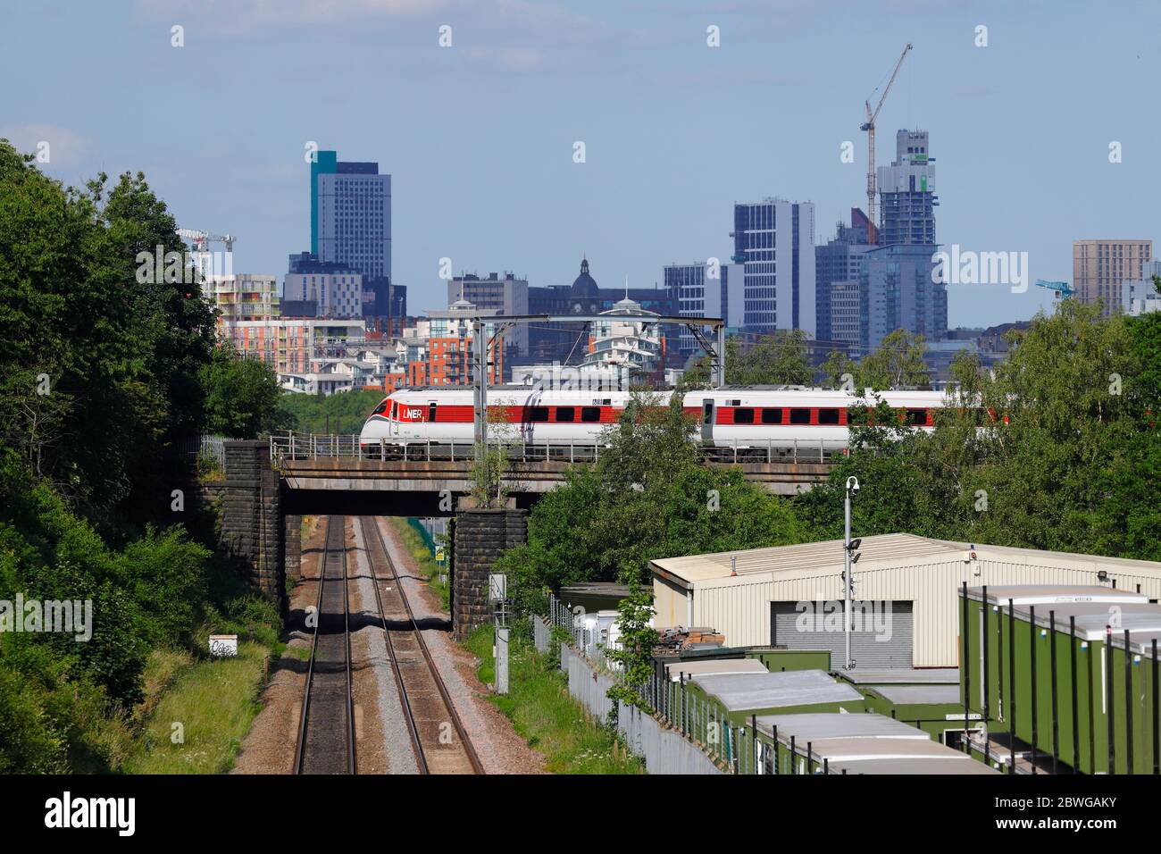 Un treno Azum classe 800 gestito da LNER passa davanti alla Leeds Skyline, mentre si dirige verso la stazione di Leeds Foto Stock