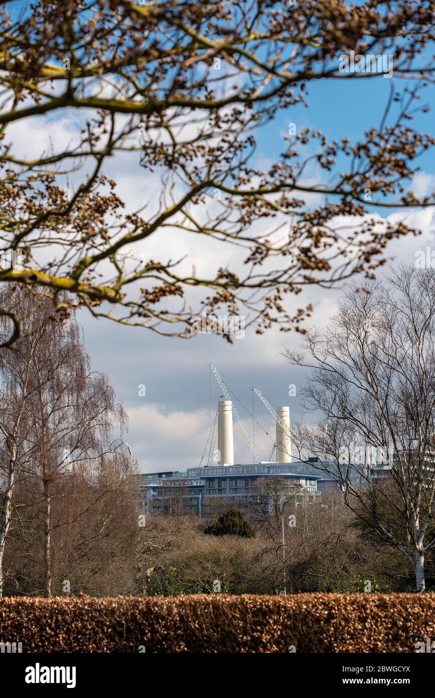 La centrale elettrica di Battersea, vista attraverso i rami di alberi in erba all'inizio della primavera da Battersea Park, unisce la natura con l'iconico grattacielo industriale di Londra Foto Stock