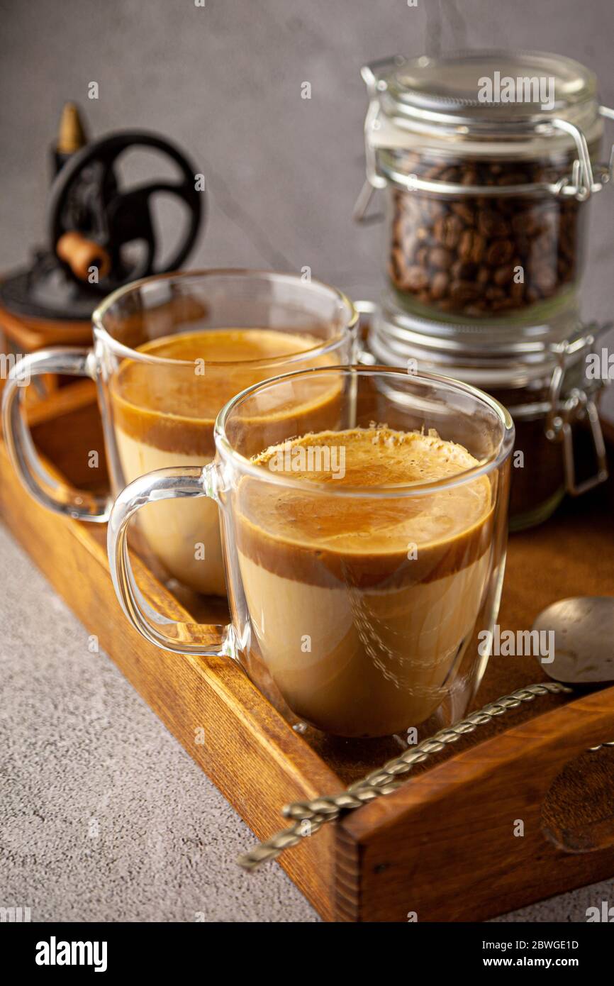 Dalgona Coffee - la bevanda coreana di caffè su sfondo di legno. Caffè istantaneo o espresso in polvere con zucchero e acqua calda. Ghiacciato montato Foto Stock