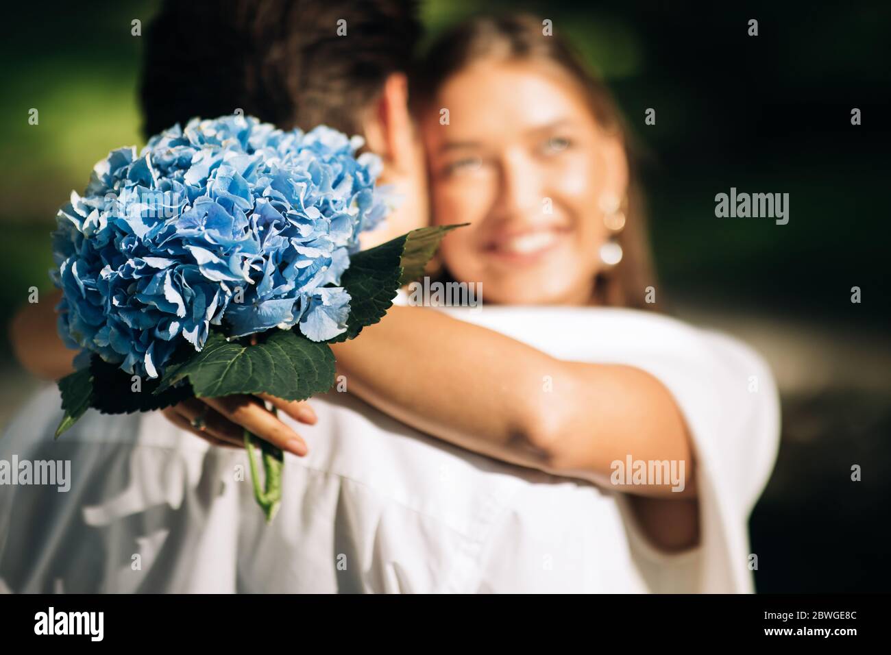 Felice sposi sposi sposi che abbracciano la posizione durante la cerimonia nuziale nel parco Foto Stock