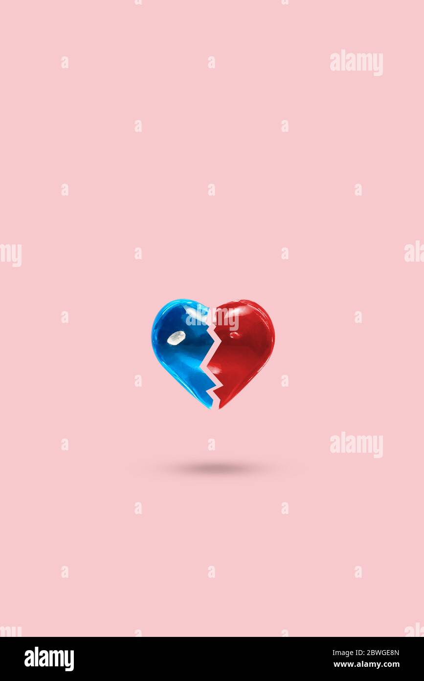 Due metà di un cuore pastello sfondo. Minimalismo. Concetto di amore, separazione Foto Stock