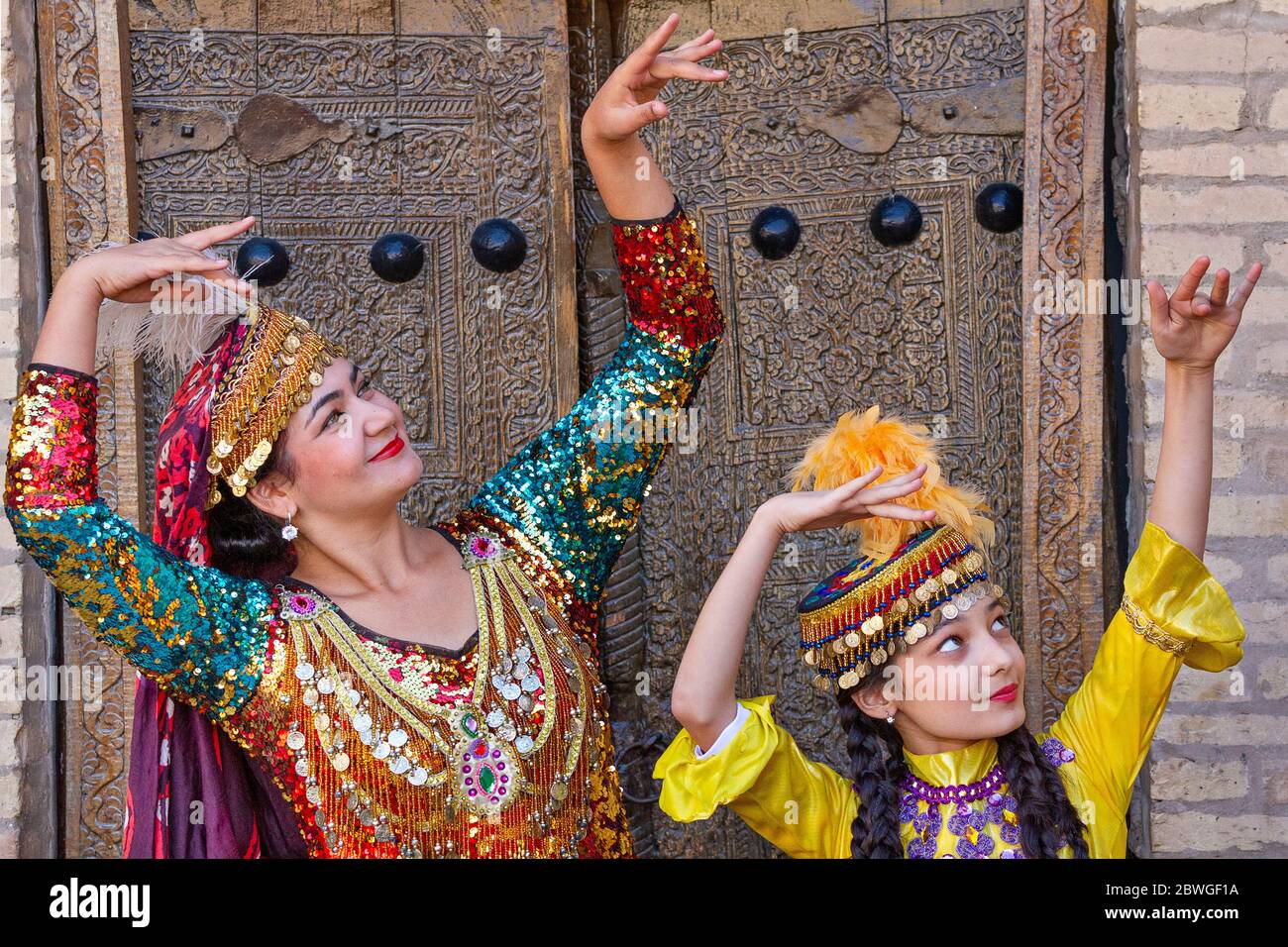 Signore uzbeko in abiti locali che eseguono danze tradizionali, a Khiva, Uzbekistan Foto Stock