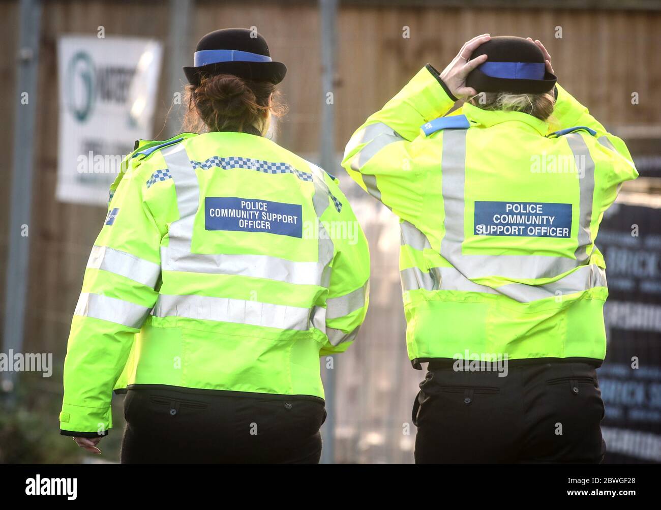 Immagine da dietro degli ufficiali di supporto della comunità di polizia (PCSO) Foto Stock