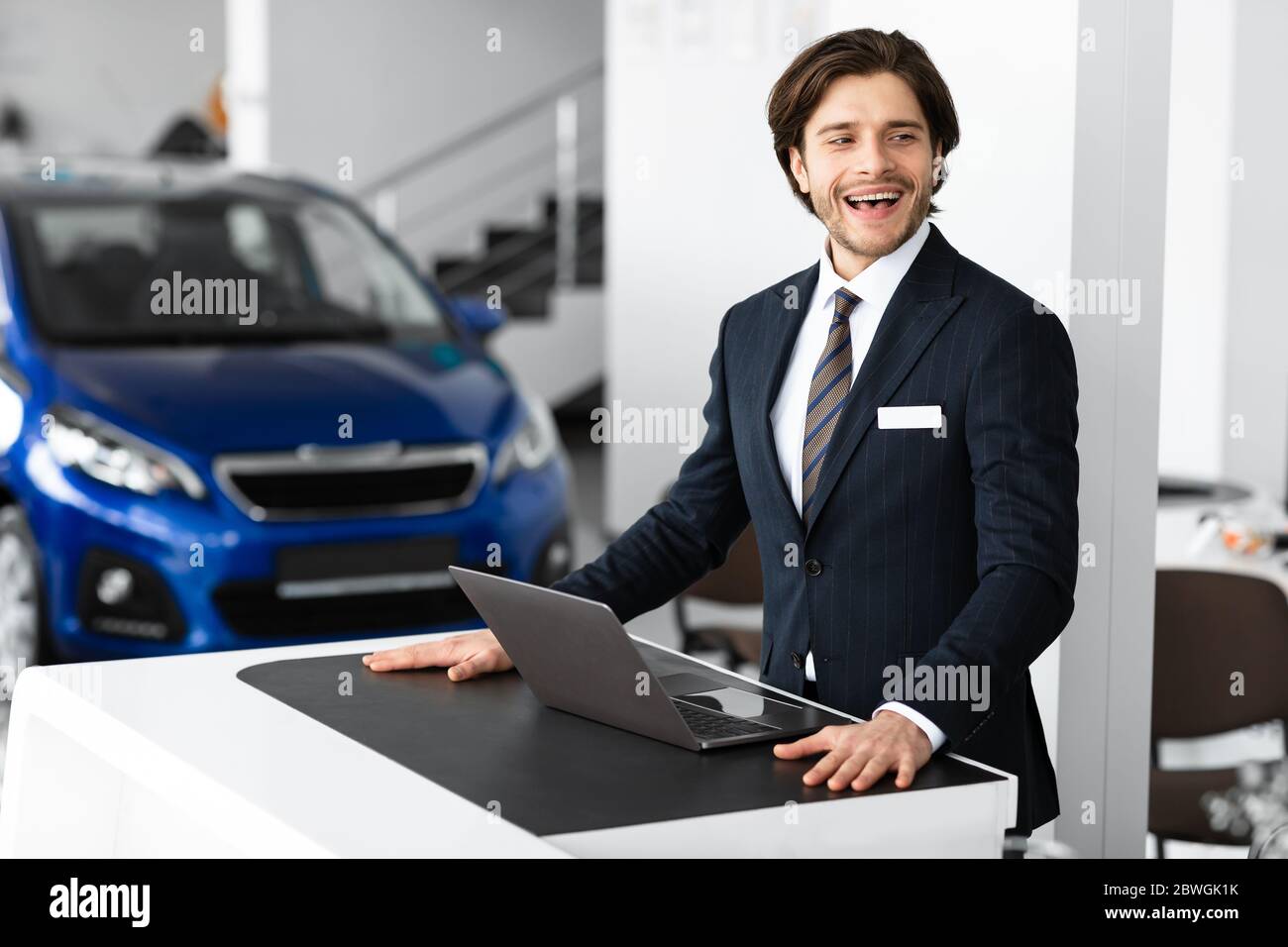 Responsabile vendite auto in posa presso l'ufficio della concessionaria di lusso Foto Stock