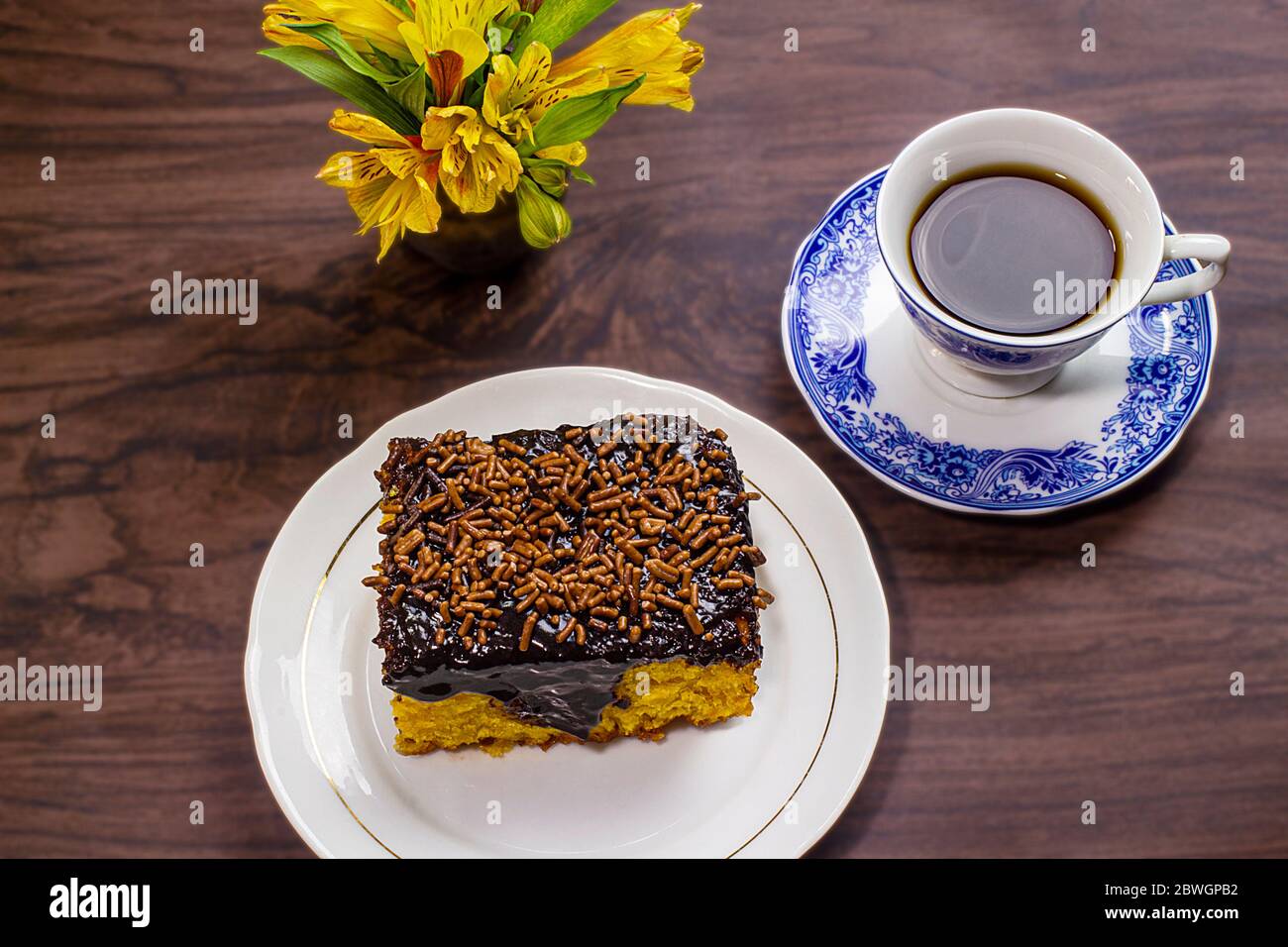 Torta di carote con glassa di cioccolato e tazza di caffè su tavolo di legno. Foto Stock