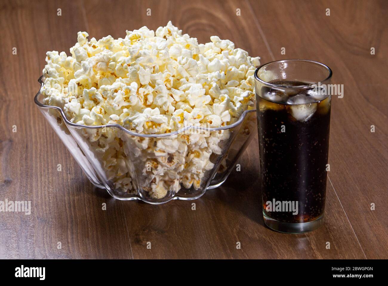 Popcorn e soda sul tavolo di legno. Foto Stock