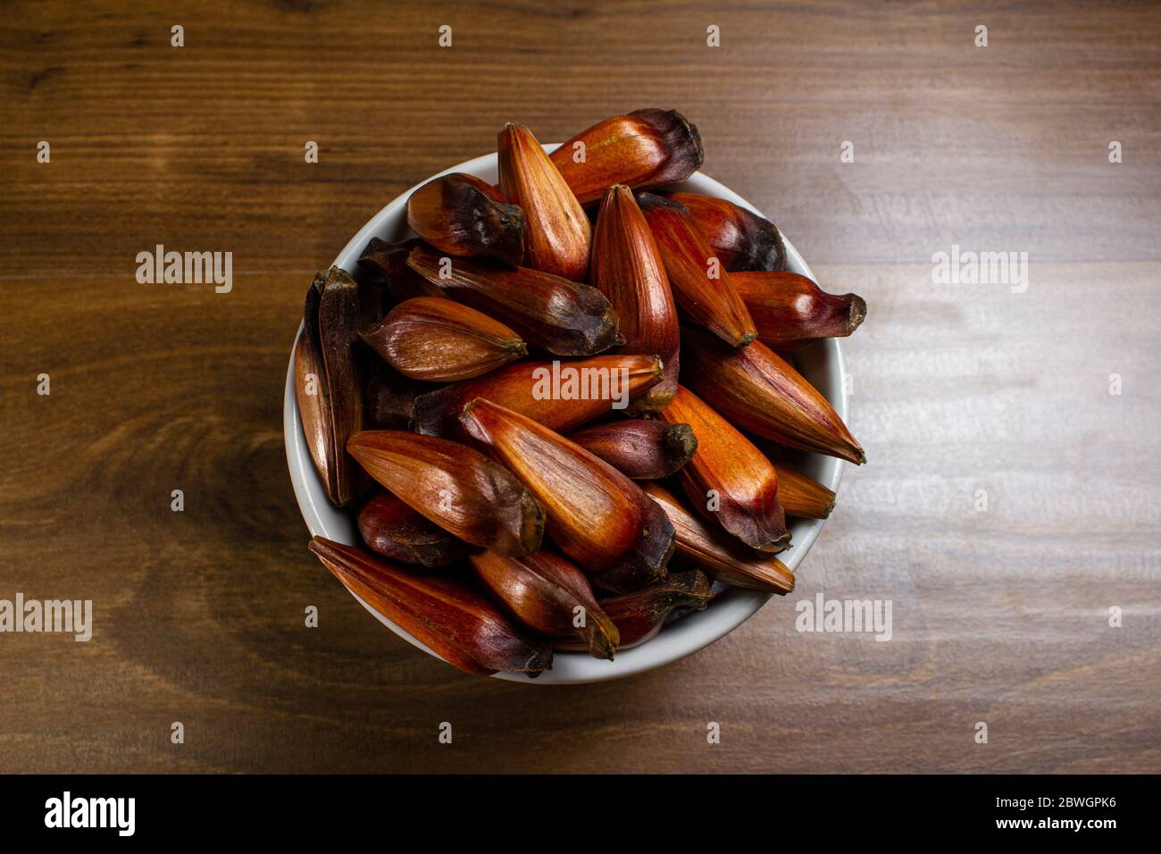 Ciotola di pinoli sul tavolo di legno. Vista dall'alto Foto Stock