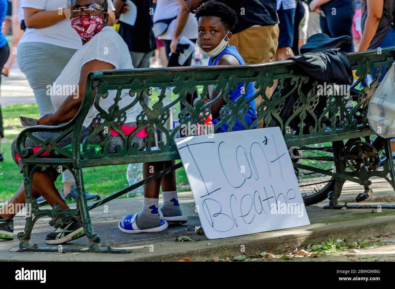 Un ragazzo si siede accanto a un poster durante una veglia per George Floyd a Cathedral Square, 31 maggio 2020, a Mobile, Alabama. Foto Stock