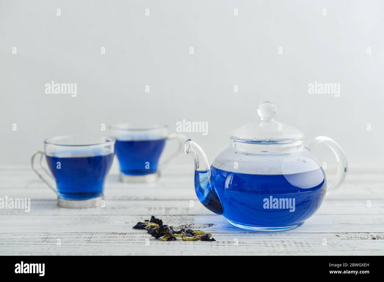 Due tazze di tè blu Anchan con teiera su sfondo bianco di legno Foto Stock