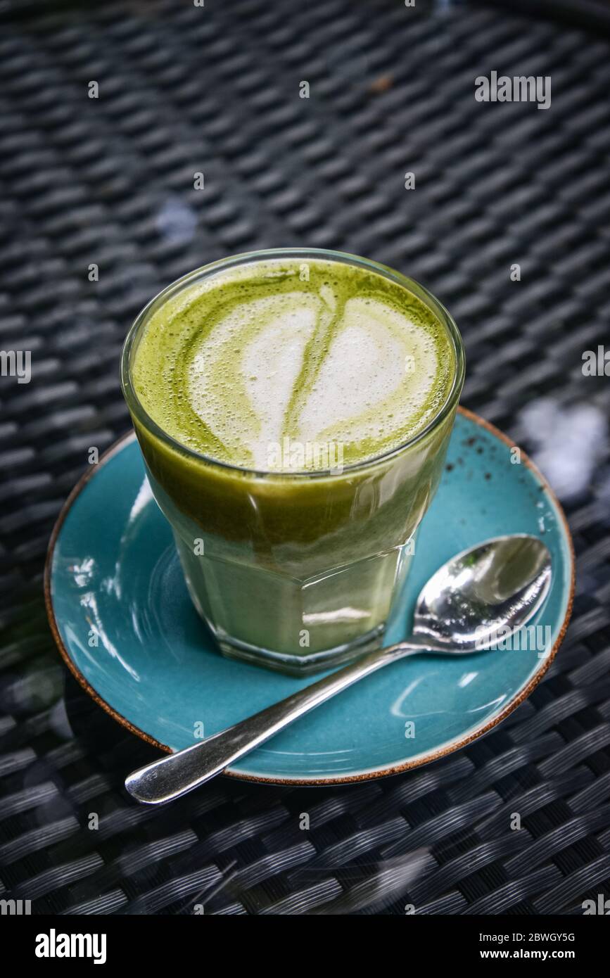 Latte Matcha in vetro sul tavolo nella caffetteria Foto Stock