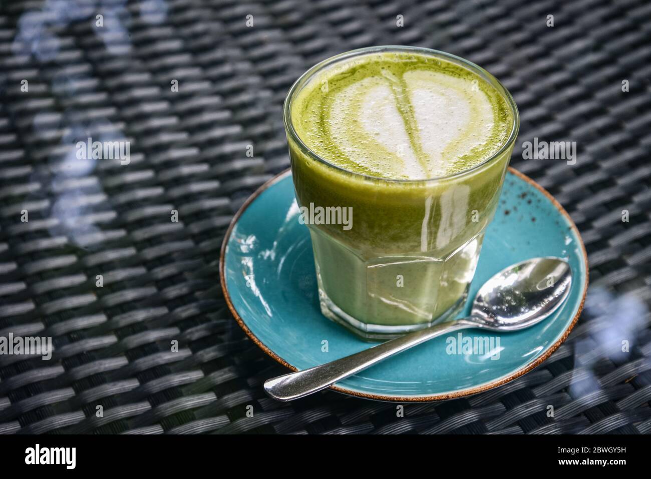 Latte Matcha in vetro sul tavolo nella caffetteria Foto Stock