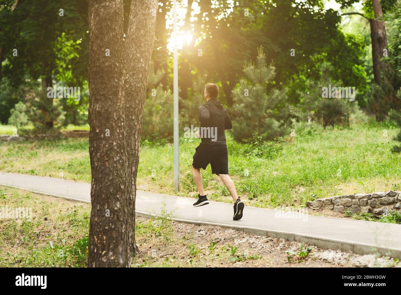 Fitness uomo sportivo che corre nel sentiero forestale Foto Stock