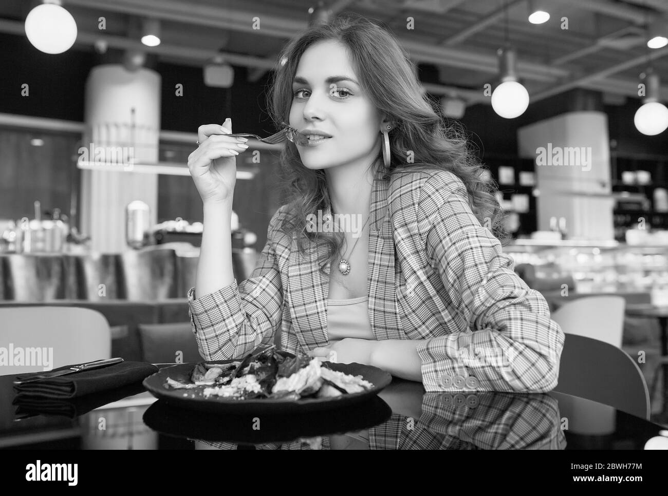 Ritratto di giovane bella donna sorridente che mangia cibo sano all'interno del bar Foto Stock