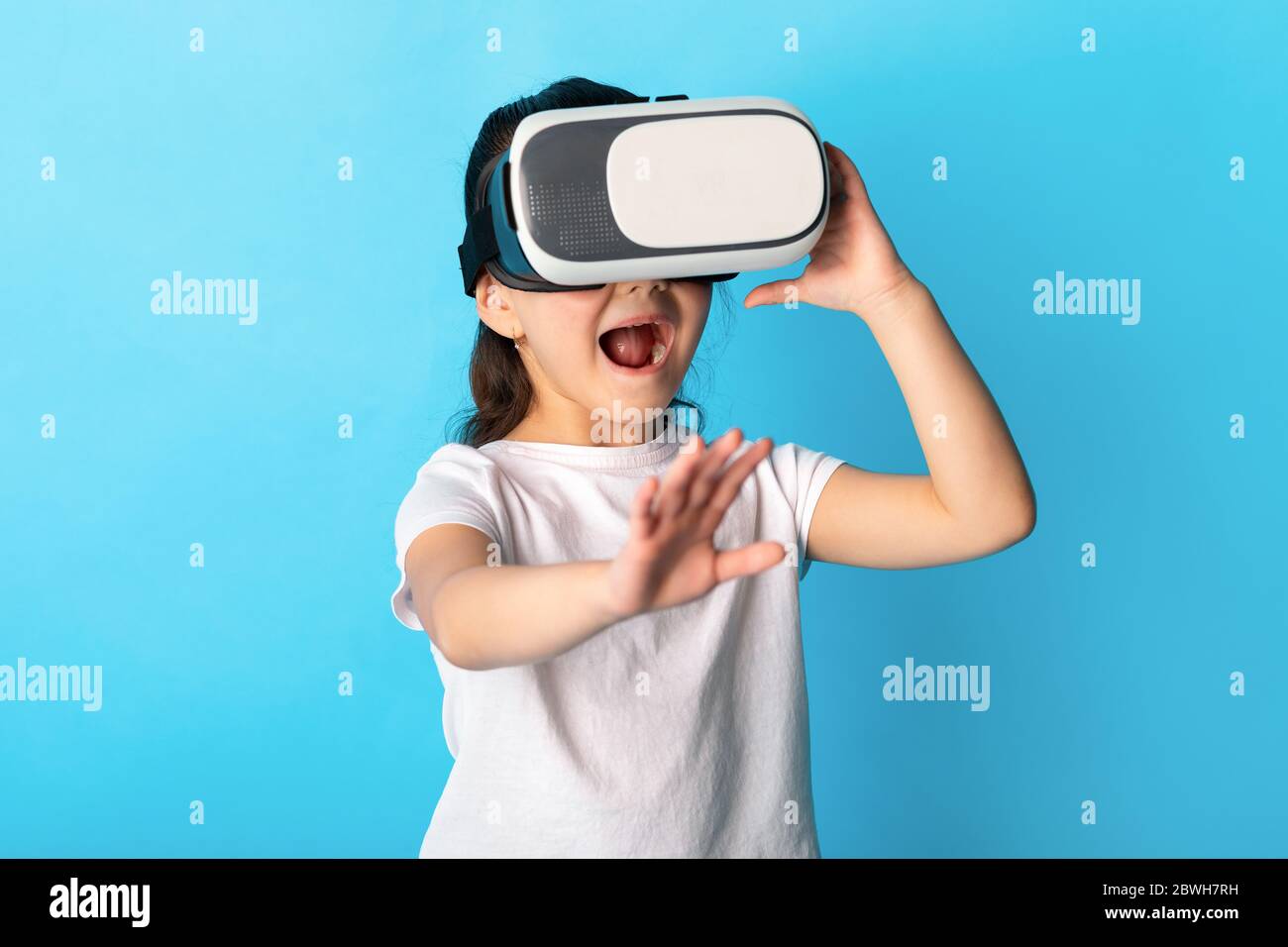 Bambina che indossa occhiali di protezione per la realtà virtuale in studio Foto Stock