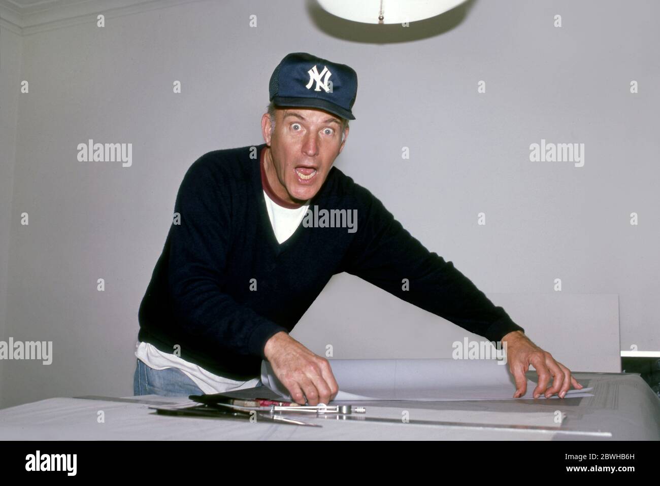 L'artista Robert Irwin indossa un cappello da baseball New York Yankees al lavoro sul tavolo nella sua casa a Los Angeles, CA circa 1983 Foto Stock