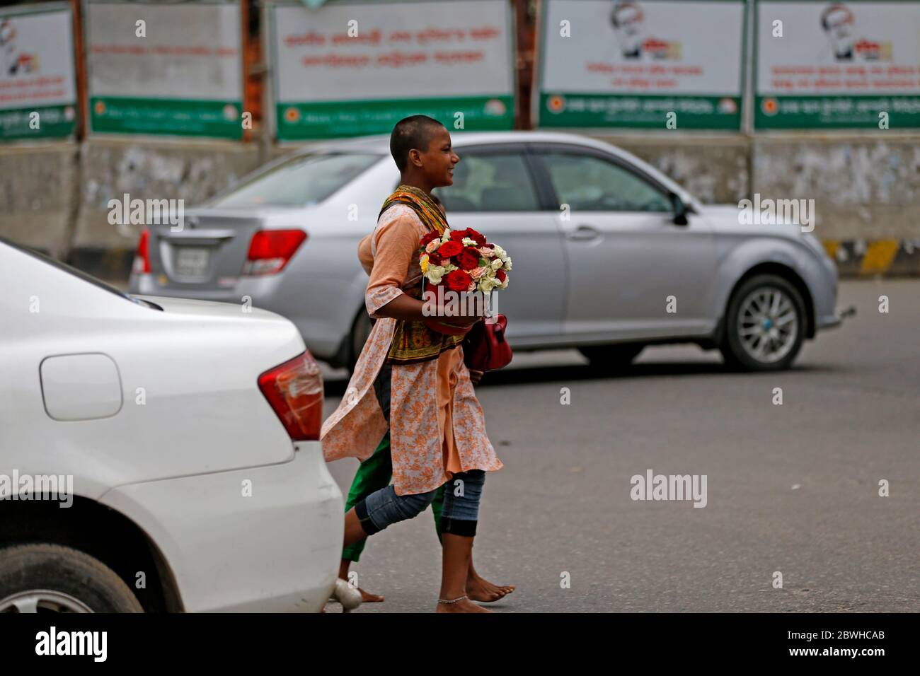 Shefali (L) lungo la sorella Selina (invisibile), di circa 14 e 11 anni, vendendo fiori e ghirlande nella zona della capitale Shahbagh. Lo spegnimento per rallentare Foto Stock