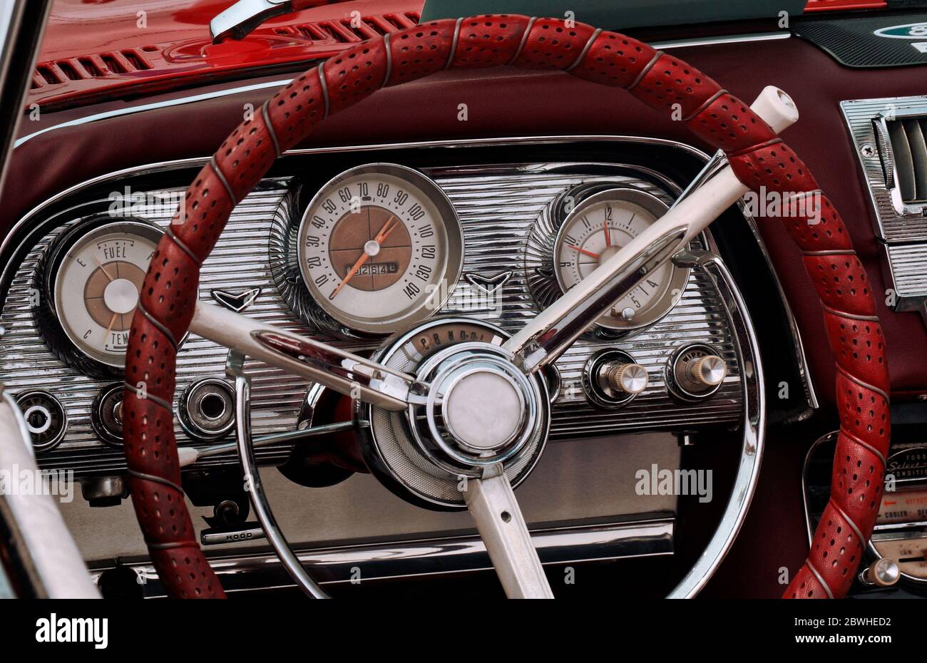 Parte dell'interno di un'auto di lusso sportiva con timer, volante, tachimetro, carburante, quadranti dell'orologio, leva del cambio, pannello anteriore Foto Stock