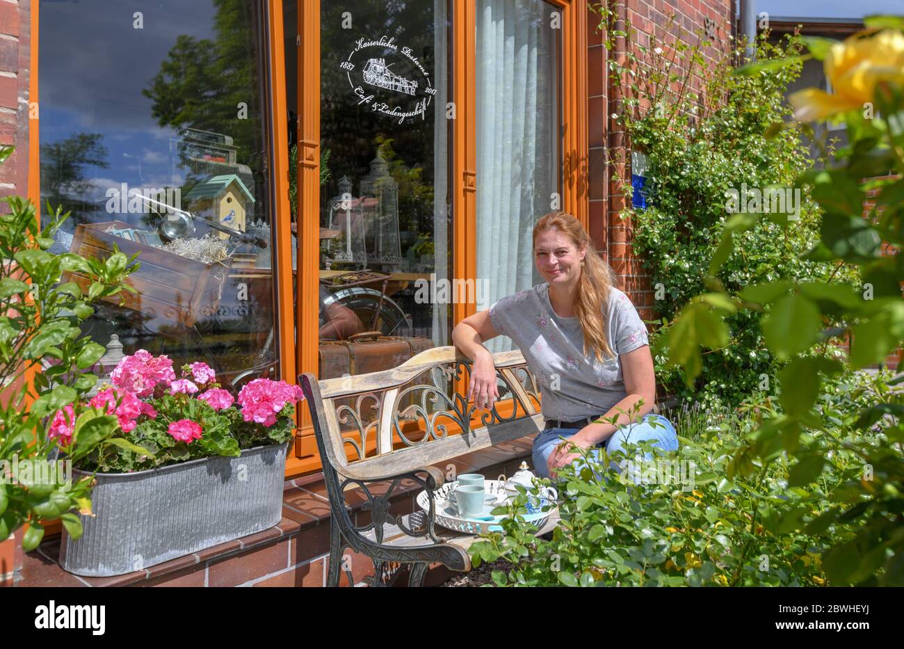 Biesenthal, Germania. 27 maggio 2020. Pamela John, operatore dell'Ufficio postale Imperiale, è seduto nel piccolo giardino di fronte al suo edificio. Da 15 anni Pamela John e il suo partner stanno rinnovando un edificio in mattoni fatiscente ma impressionante a Biesenthal. Solo attraverso le loro ricerche si sono resi conto che era una casa immersa nella storia. (A 'caffè e torta nell'Ufficio postale Imperiale') Credit: Patrick Pleul/dpa-Zentralbild/ZB/dpa/Alamy Live News Foto Stock