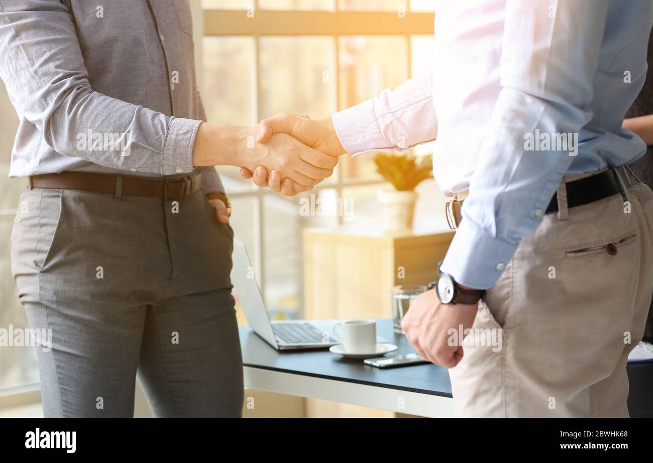 Uomini che scuotono le mani nell'ufficio dell'avvocato Foto Stock