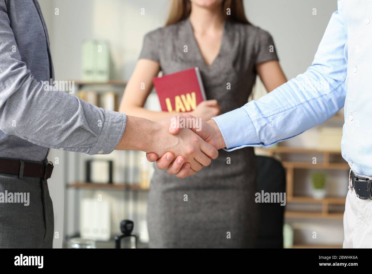 Uomini che scuotono le mani nell'ufficio dell'avvocato Foto Stock