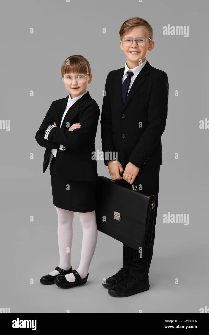 Ritratto di piccoli segretari su sfondo grigio Foto Stock