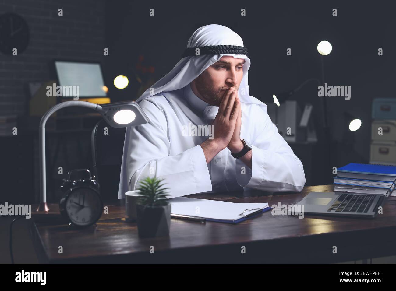 Uomo d'affari arabo che lavora in ufficio a tarda notte Foto Stock