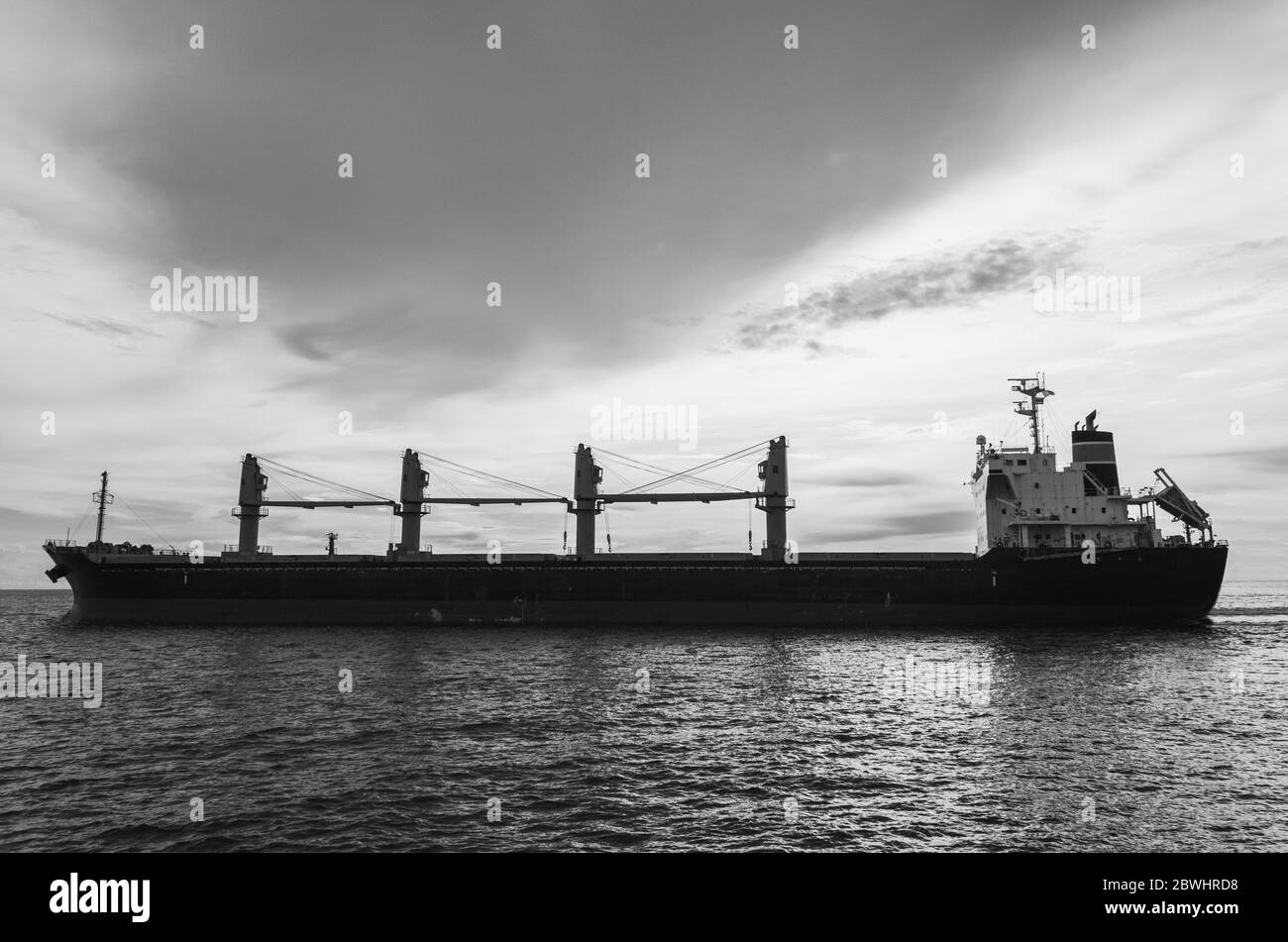 Grande nave in mare aperto con cielo drammatico bianco e nero Foto Stock