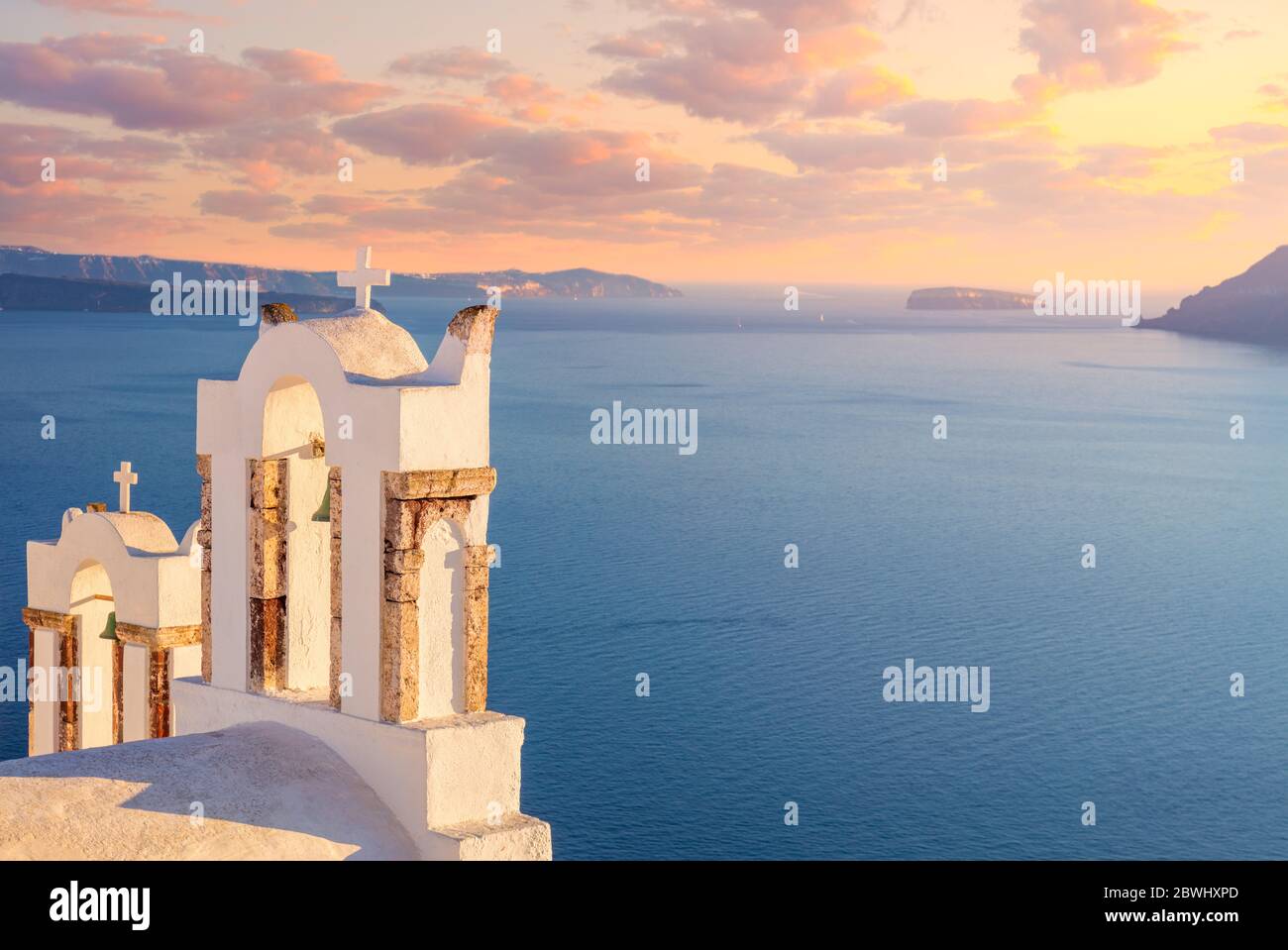 Serata dolce - tramonto romantico sulla popolare localita' turistica dell'isola di Santorini. Arco con una campana, mare blu e romantico cielo di tramonto a Oia al tramonto, isola San Foto Stock