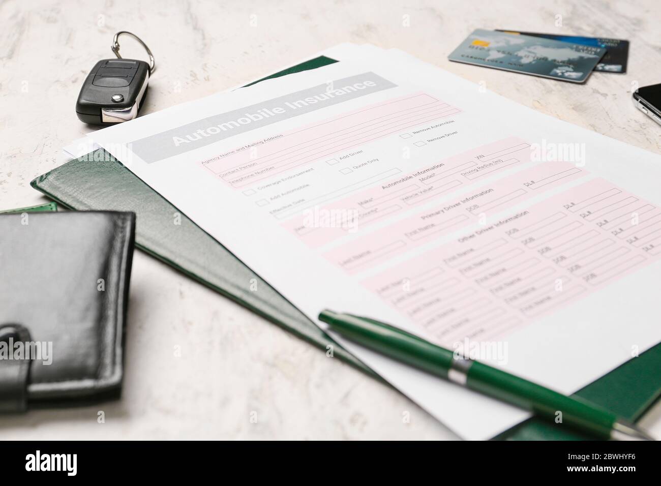 Modulo di assicurazione auto con portafoglio e chiave su sfondo chiaro Foto Stock