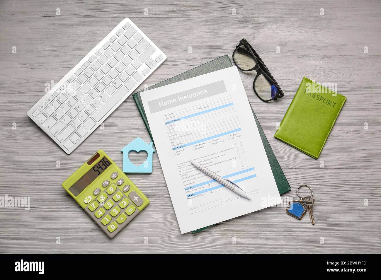 Modulo assicurazione domestica con tastiera, chiave, passaporto e calcolatrice sul tavolo Foto Stock