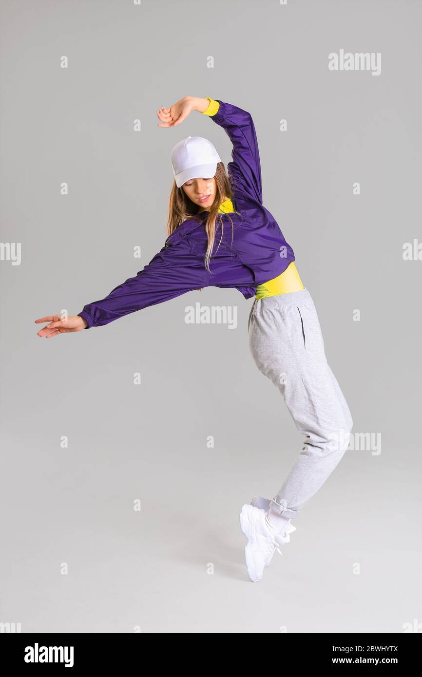 Giovane ballerina hip-hop femminile su sfondo grigio Foto Stock
