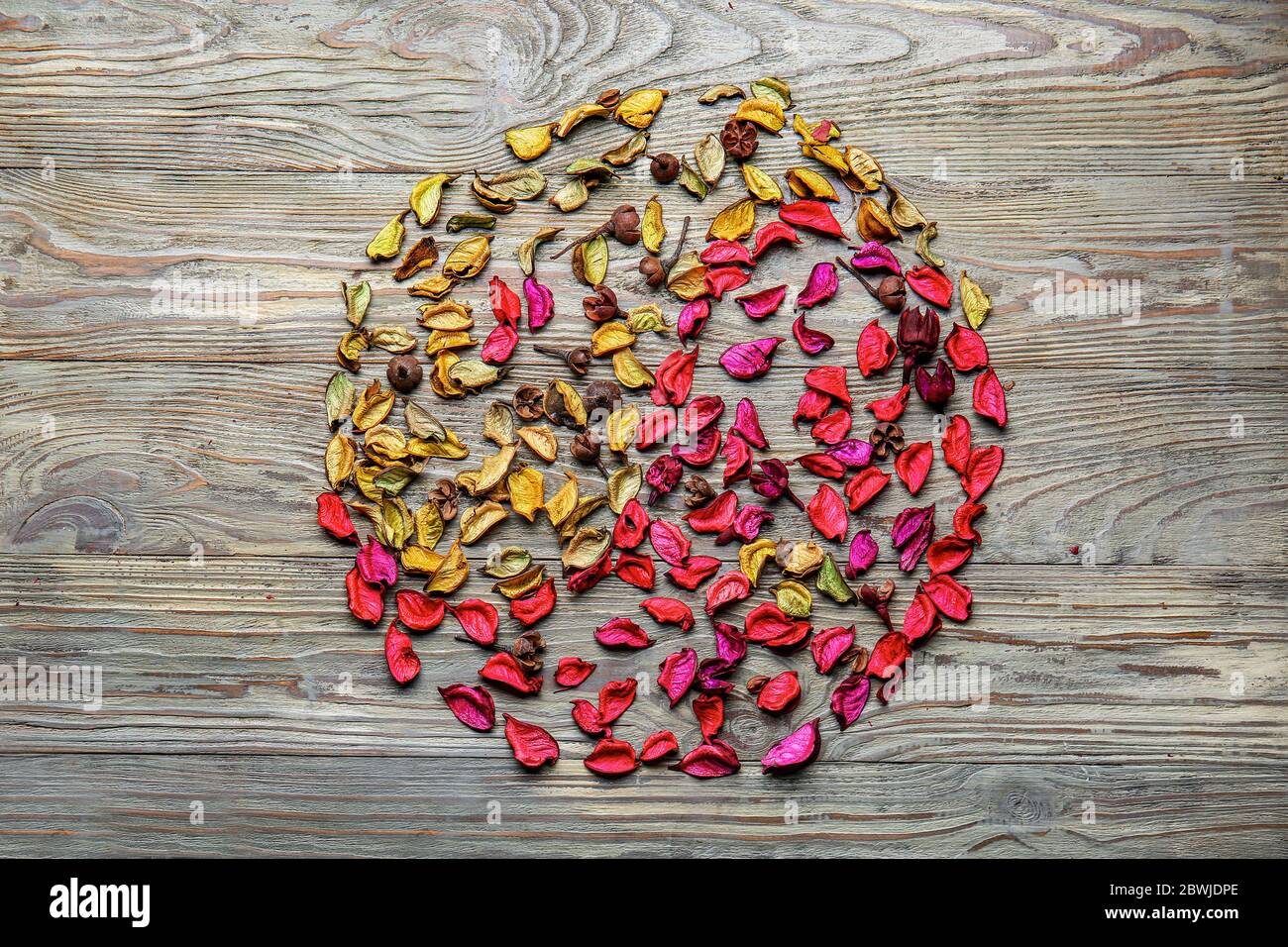 Simbolo Yin-yang fatto di petali secchi su sfondo di legno. Concetto Zen Foto Stock