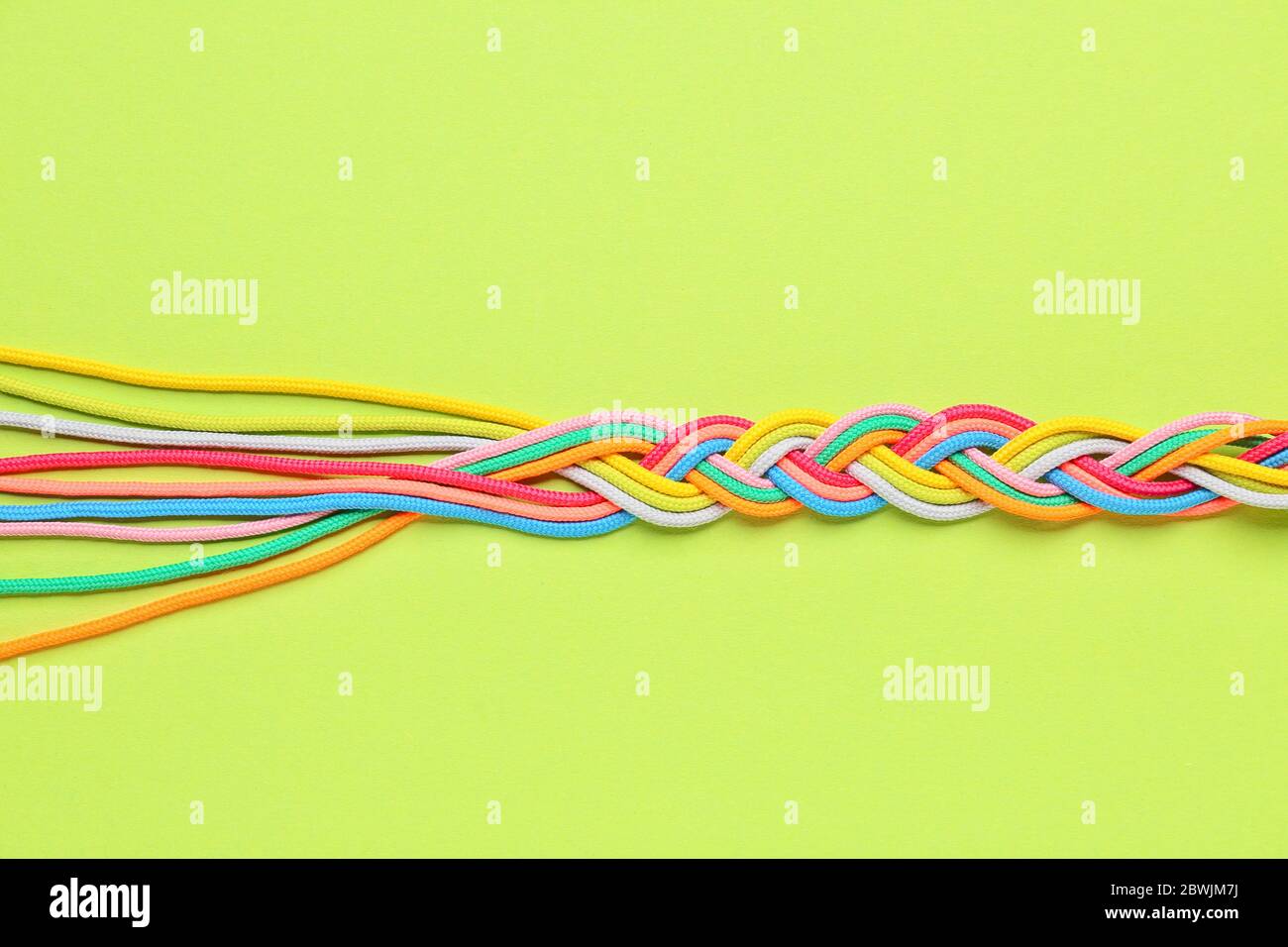 Corde intrecciate su sfondo colorato. Concetto di unità Foto Stock